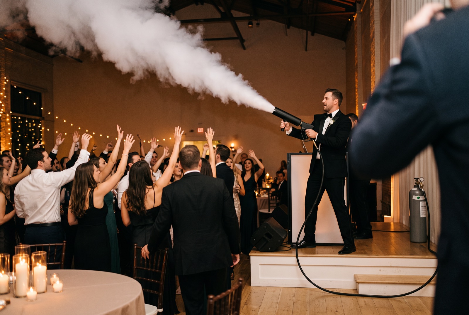 Handheld CO2 cannon fired over the dance floor at a Miami wedding reception, hose running to the tank